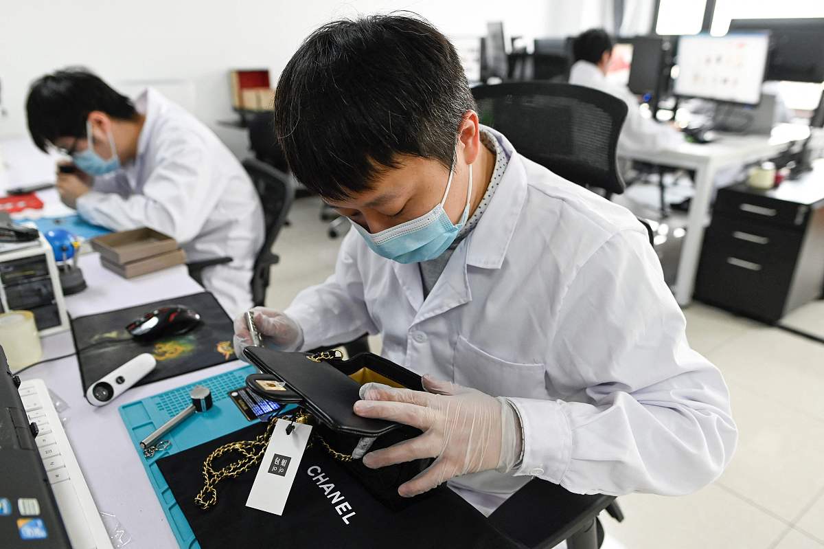 2021年3月24日,北京,"非凡奢侈品科技公司"的一名工作人员在鉴定手袋