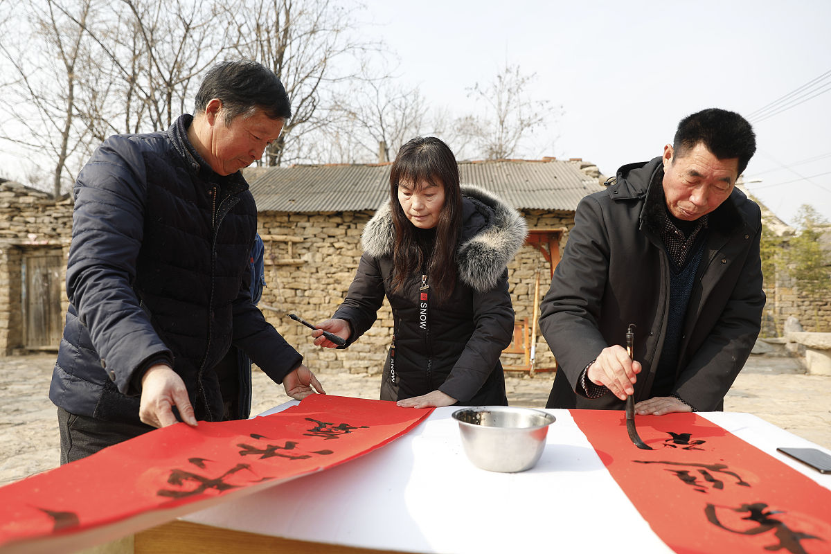 2020年1月4日,书法爱好者在河南省平顶山市宝丰县前营乡郝庄村为村民