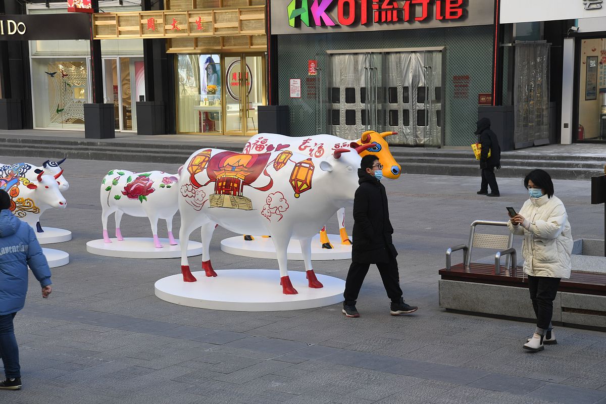 2021年1月1日,在沈阳中街街头,十头"彩牛"与市民见面,引来过往市民纷