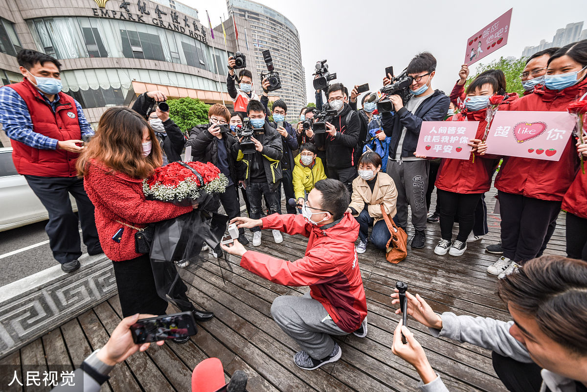 把下面内容进行改写洗稿3月29日根据陕广电报后浪视频报道近日在四川达州一段男子带鲜花下跪的视频引发关注。视频中一名身穿白色衬衫的男子手捧99朵玫瑰在一家餐厅门口向一名身穿红色连衣裙的女子下跪求婚。周围的人群纷纷围观为他们加油打气。