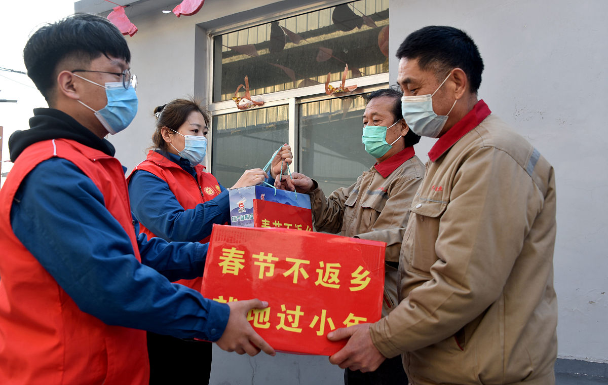 2021年2月4日,山东滨州,在博兴县一家企业,志愿者与外来务工人员一起