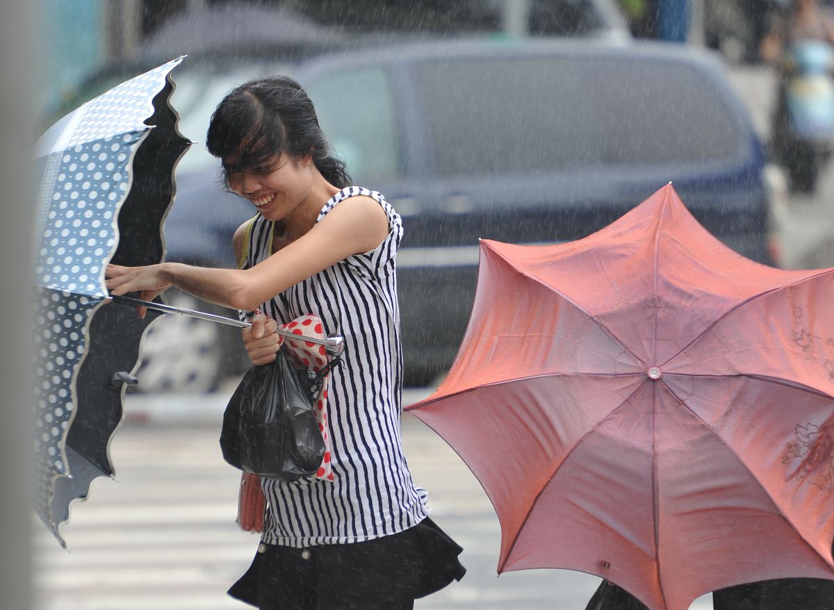 描写一个身穿职业套装的美女在公交站台里躲大雨的画面