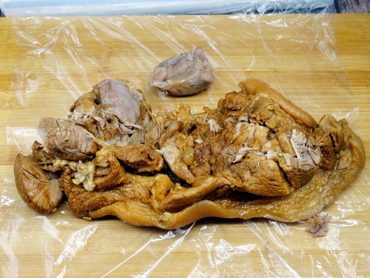 趁肘子温热的<strong>时候</strong>,放在保鲜膜上,肉皮朝下,用保鲜膜卷起来,两头系上
