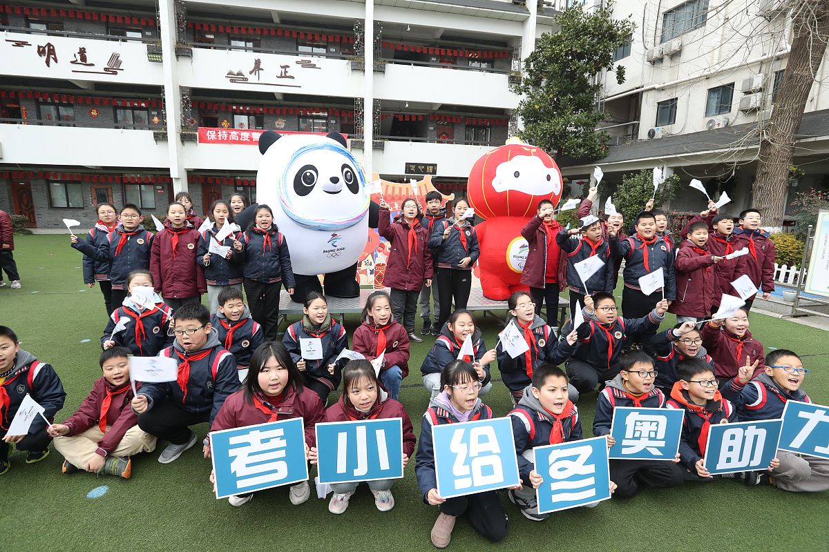 2022年2月14日,南京市秦淮区考棚小学的学生与冬奥吉祥物合影,迎接新