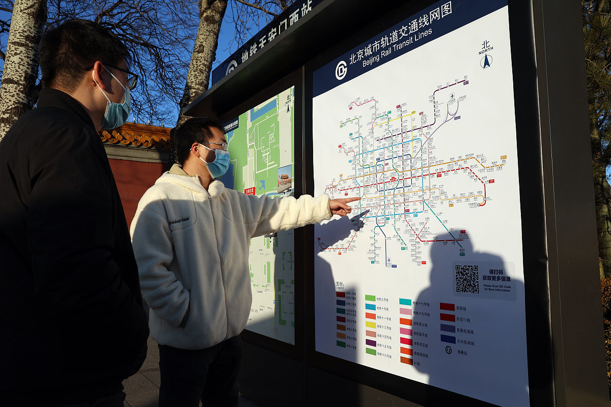2021年12月30日,北京,游客在新换的地铁线路图上查询路线.