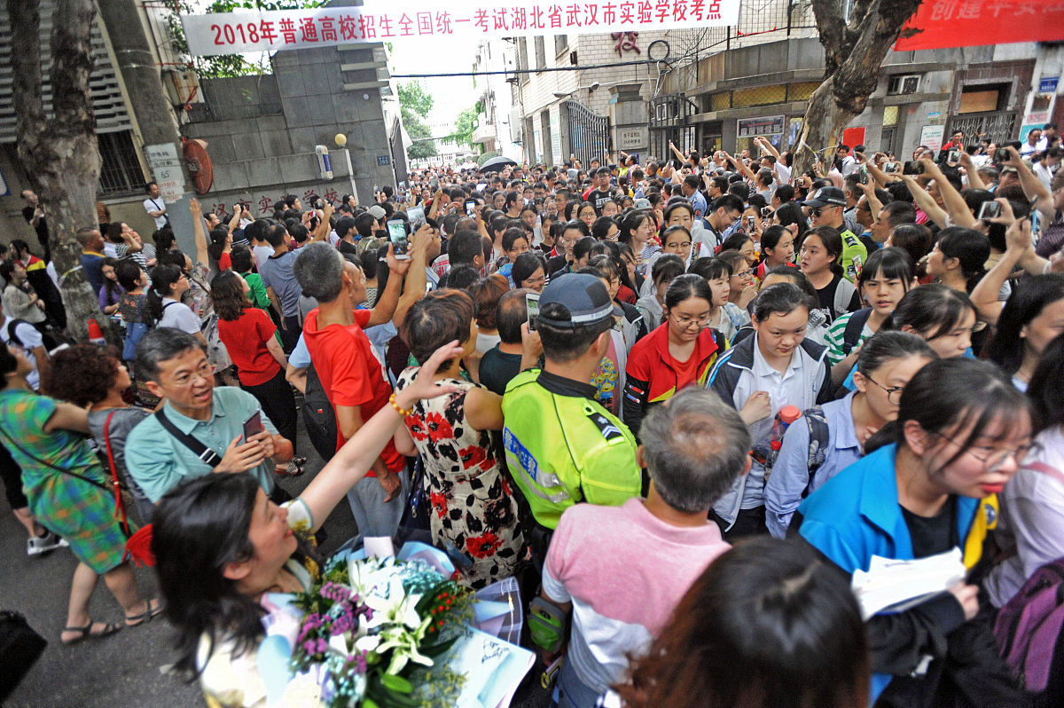 2018年6月8日,武汉市实验学校考点,如潮考生涌出考场,送考家长手捧鲜