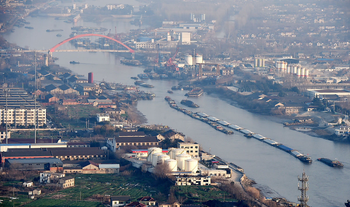 镇江港位于长江下游南岸江苏省中部的镇江市与扬州市隔长江相望为京杭运河与长江的交汇处。镇江港是长江三角洲地区综合运输体系的重要枢纽是上海国际航运中心集装箱运输体系的重要组成部分和集装箱运输的支线港是长江沿线能源原材料物资海进江运输的主要中转港之一是长江中上游地区内外贸物资江海转运的重要港口是镇江市发展临江产业和现代物流的重要依托。这句话降重