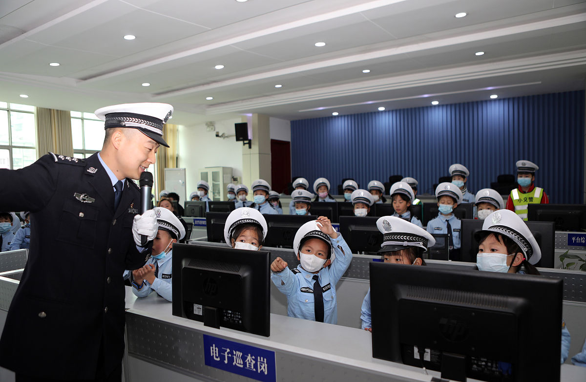 2021年2月28日,重庆,交巡警向"萌娃"讲解高清电子监控屏幕的作用.