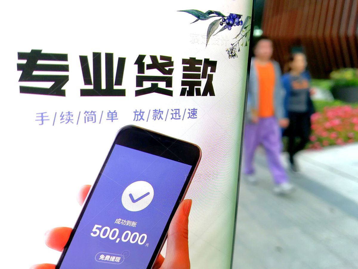 2020年11月17日,两人正从显示有"专业贷款"的显示屏前走过.