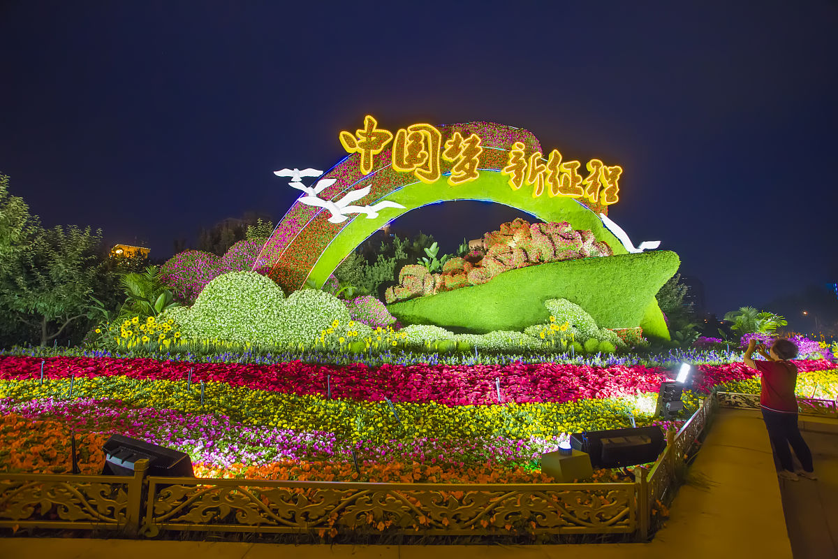 2021年6月29日,北京东西长安街10组主题立体花坛惊艳亮相,夜色中更显