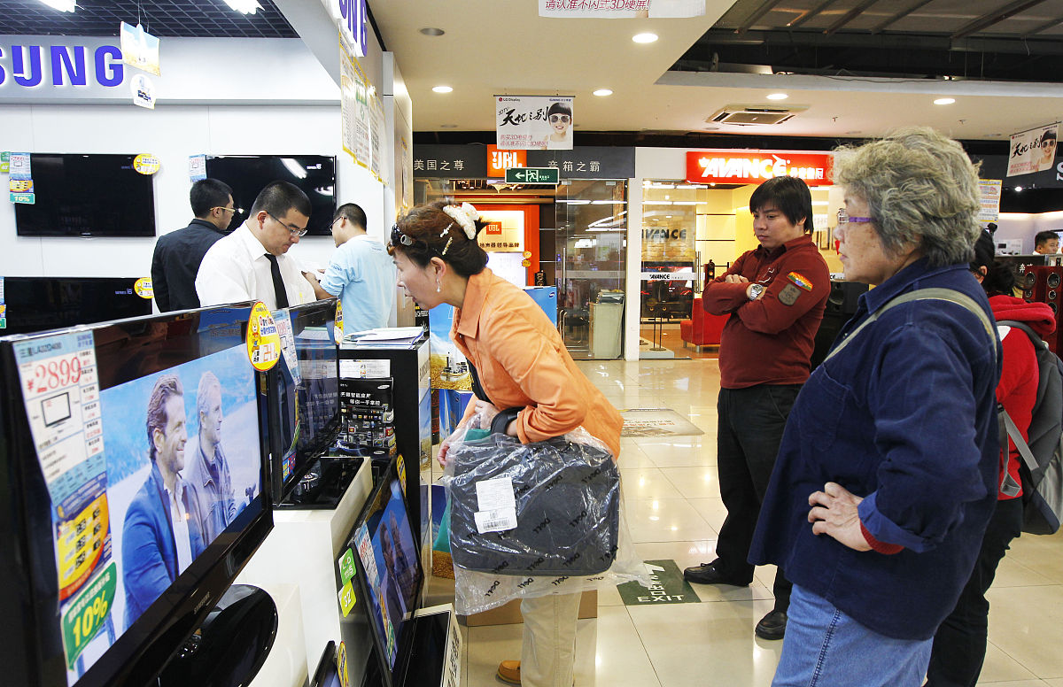 2011年10月1日,北京苏宁电器刘家窑店,顾客在看液晶电视的节能补贴和