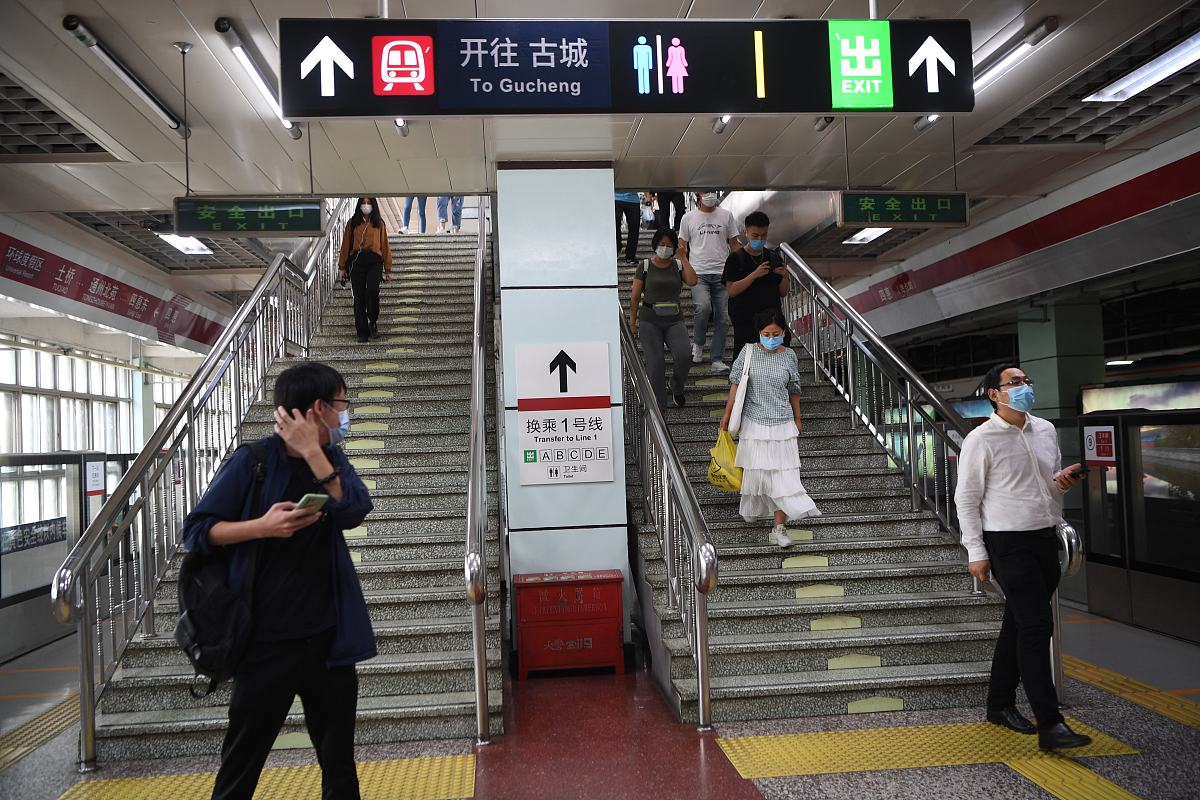 2021年8月28日,北京,工作人员在四惠地铁站粘贴通告,地铁站里的换乘标