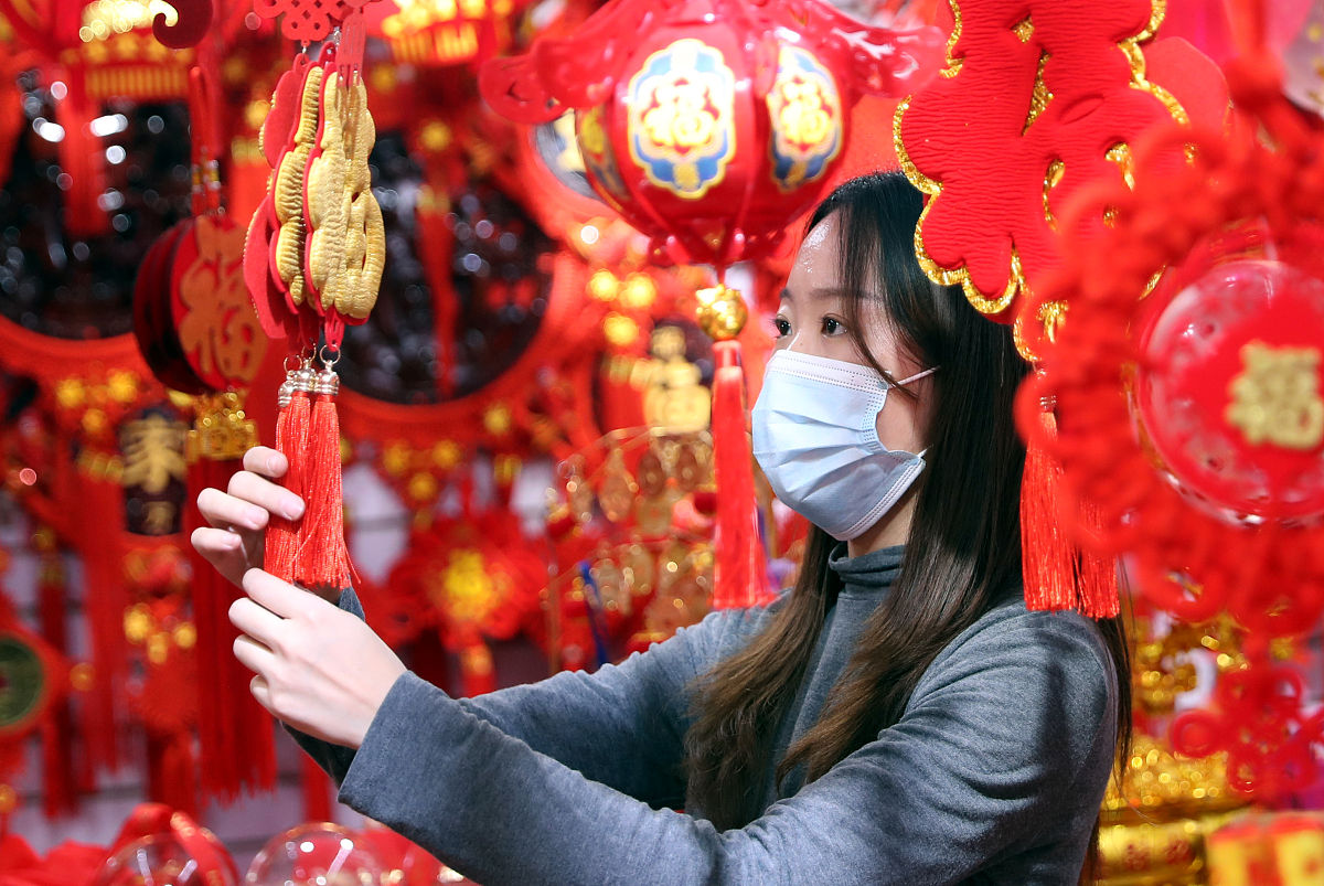 2020年12月15日,乌鲁木齐市华凌市场年货饰品店里,人们正在挑选红红火