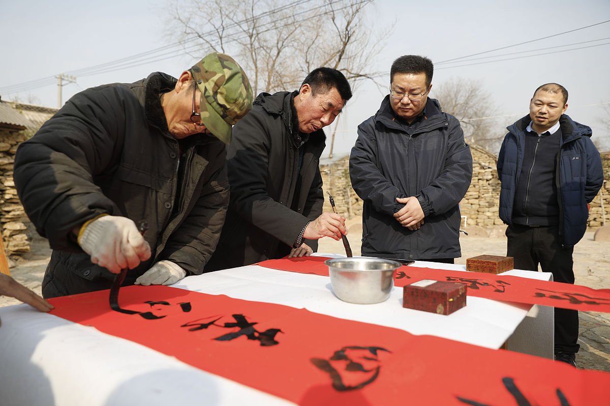 2020年1月4日,书法爱好者在河南省平顶山市宝丰县前营乡郝庄村为村民