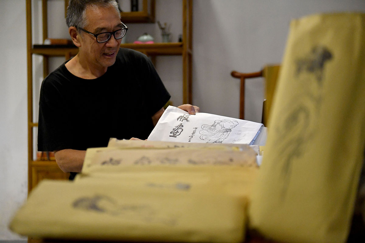 2018年8月18日,山东青岛,复刻拓印好的版画拎印.高文举老人年过古稀,