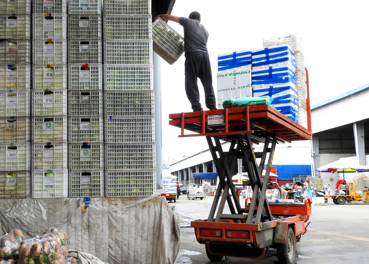 2021年9月26日,江苏连云港,四季农产品批发市场,商户在卸载刚刚运到的