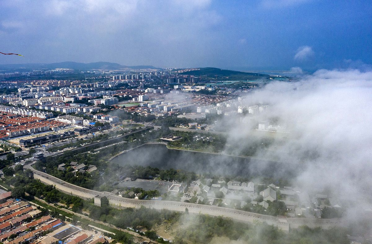 2021年7月28日,山东烟台,蓬莱区城市上空被平流雾笼罩着,蓬莱阁景区,
