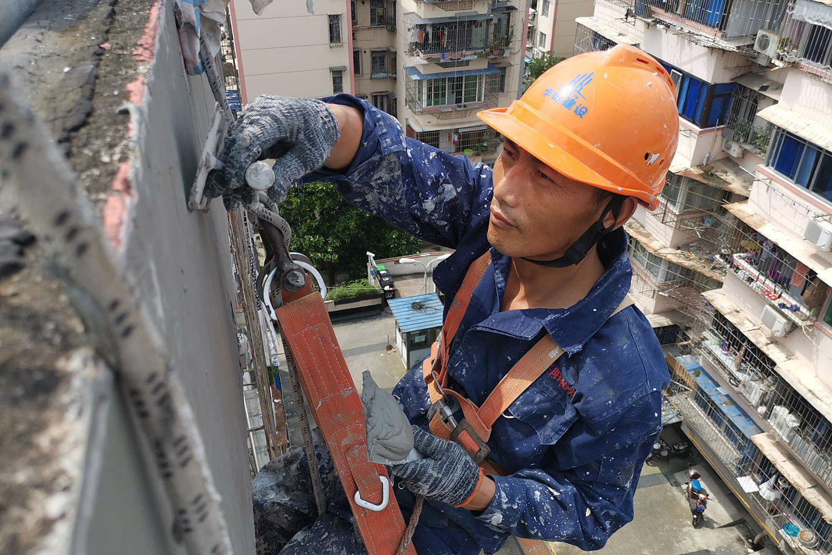 2021年8月18日,一位建设工人悬吊在浙江省宁波市海曙区新街小区的一栋