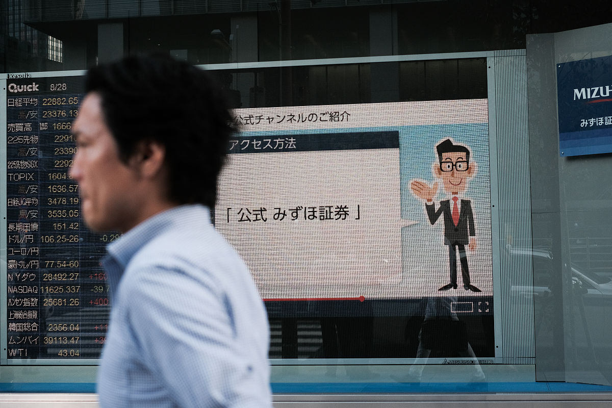 当地时间2020年8月28日,日本东京,证券公司外的股票信息.a pedestrian