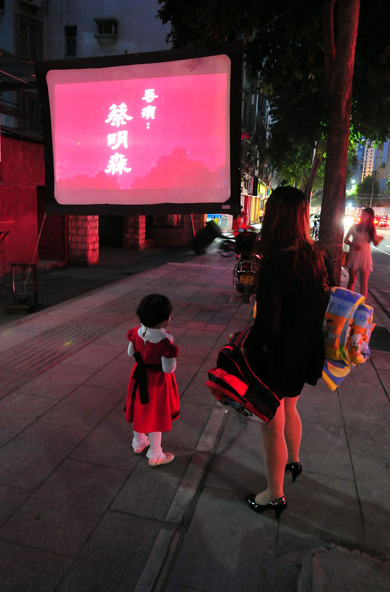 2012年10月26日,福州,露天电影引起一位路过小朋友的好奇.
