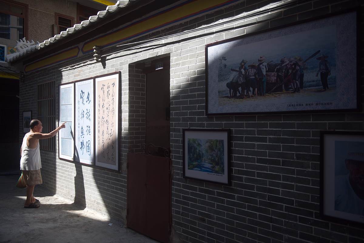 2016年7月17日,海南琼海,一位市民在溪仔古街观看书法展览.