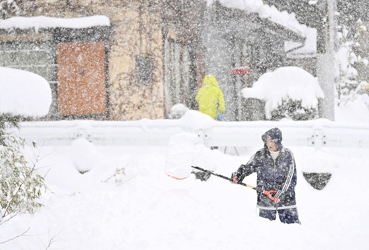 当地时间2020年12月16日,日本东部群马县南上市,民众清理积雪.a woman