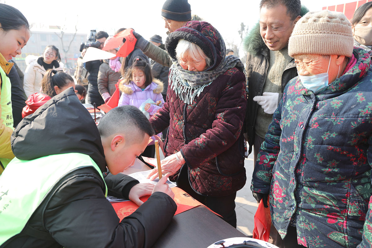 2018年2月7日,江苏徐州,青少年"书法家"为市民书写春联.