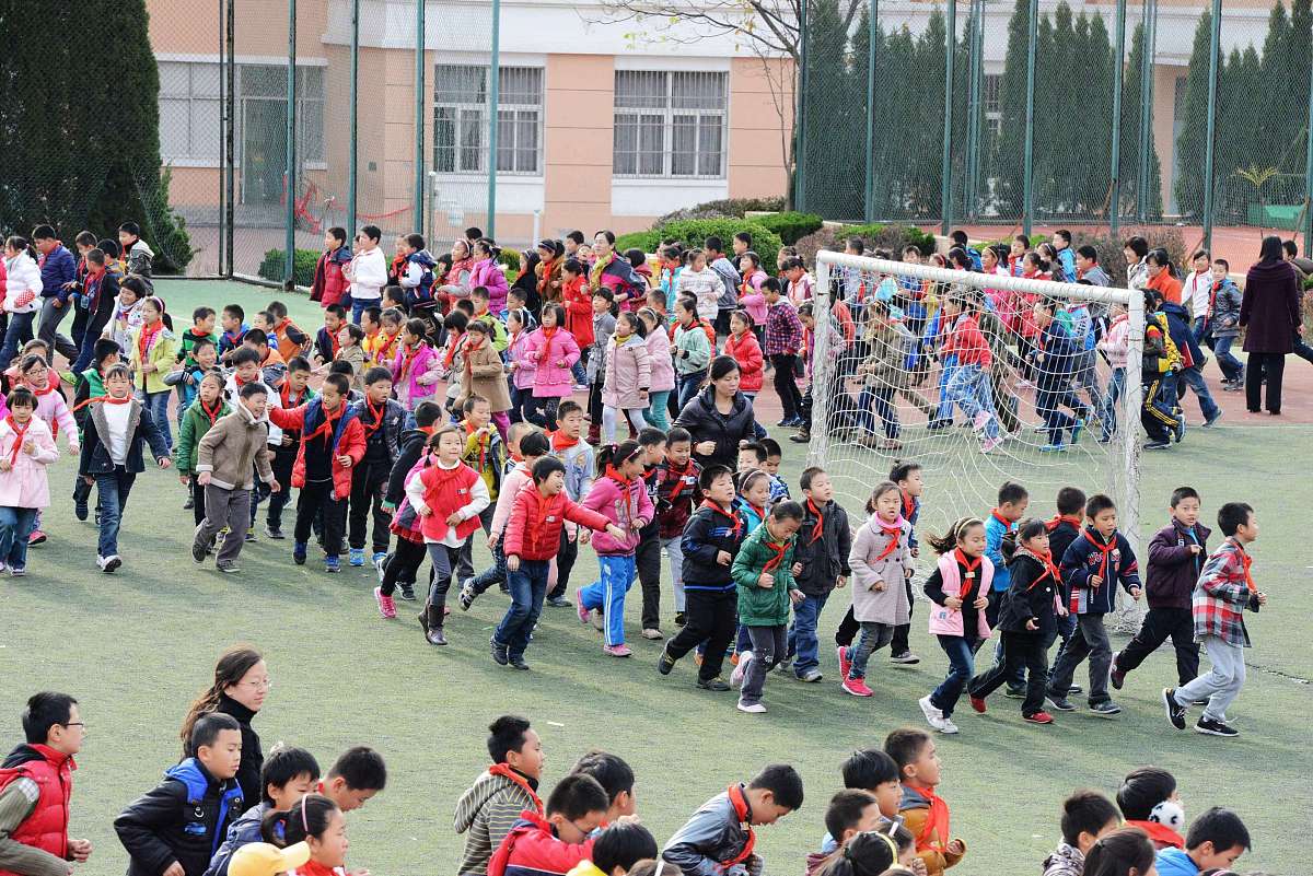 2012年11月21日,山东青岛一小学学生在课间操时间练习跑步.