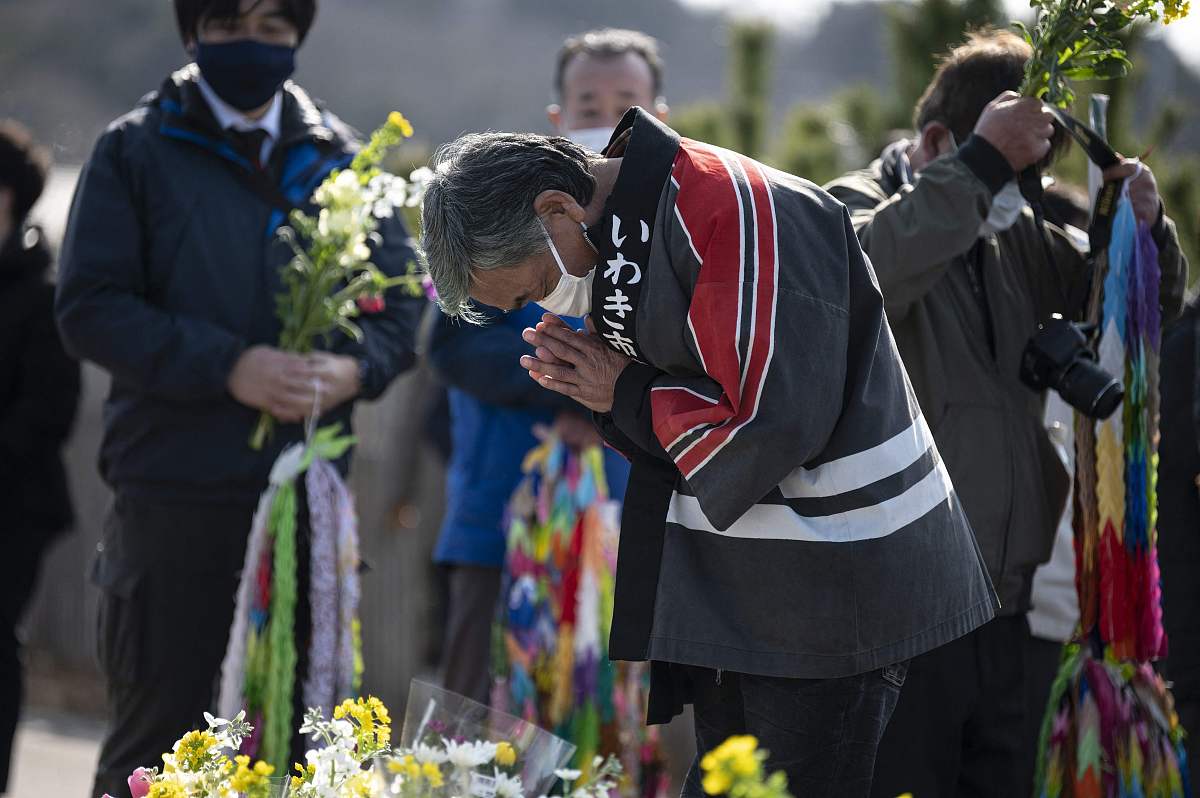 当地时间2021年3月11日,日本久之滨,民众和僧侣前往海边悼念遇难者,纪