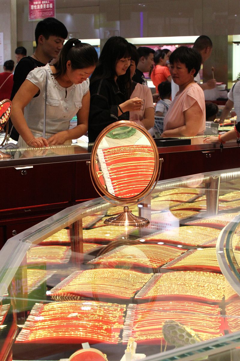 2016年5月22日,河南许昌,市民在一家专卖店选购黄金首饰.