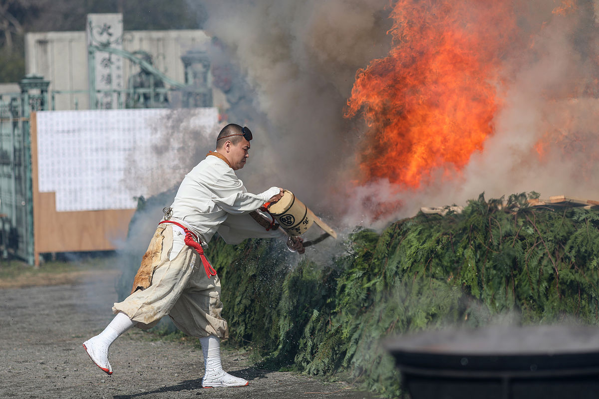 当地时间2021年3月14日,日本八王子市,僧侣在走火节的祈祷仪式上浇灭