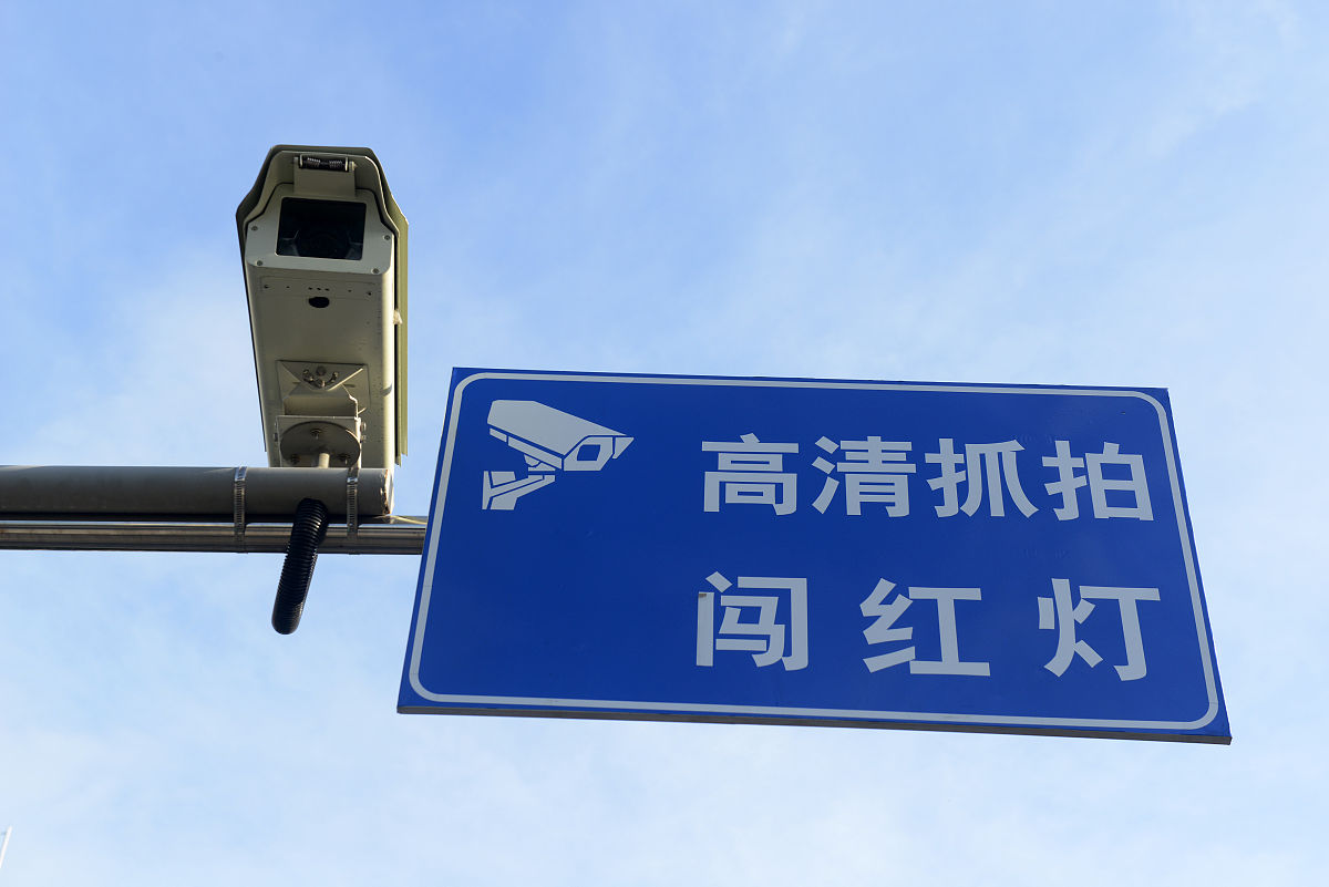 2021年8月3日,福州,多个人流量大的路口,悬挂"高清抓拍闯红灯"的提示.