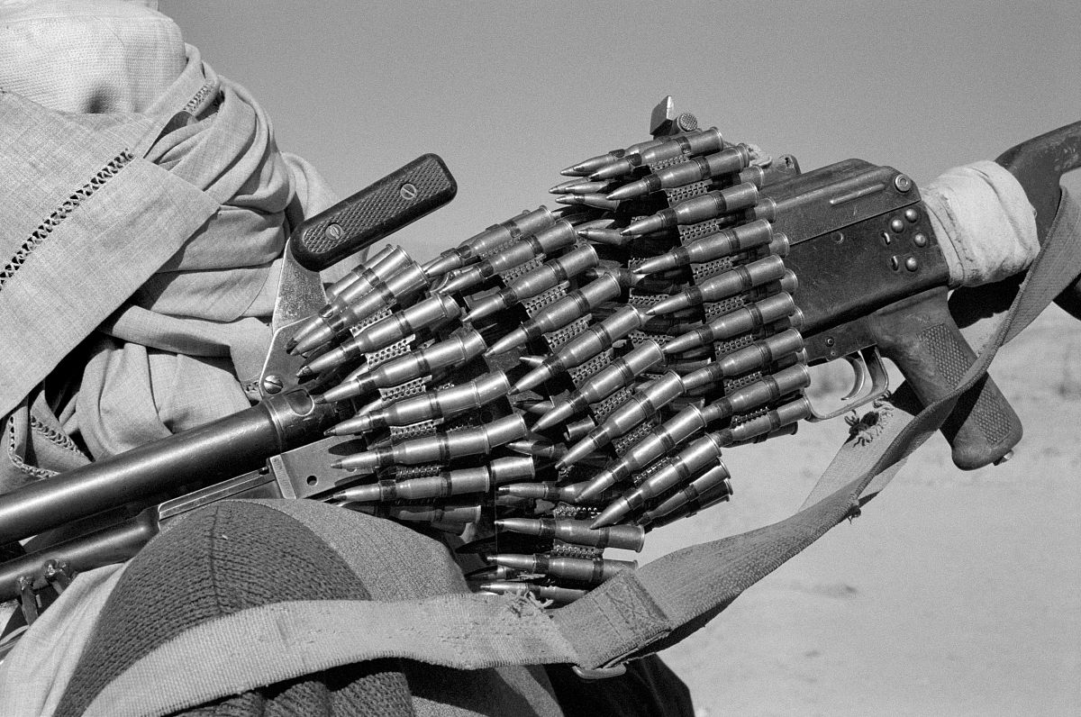 close-up of an automatic rifle wrapped in an ammunition belt, ka