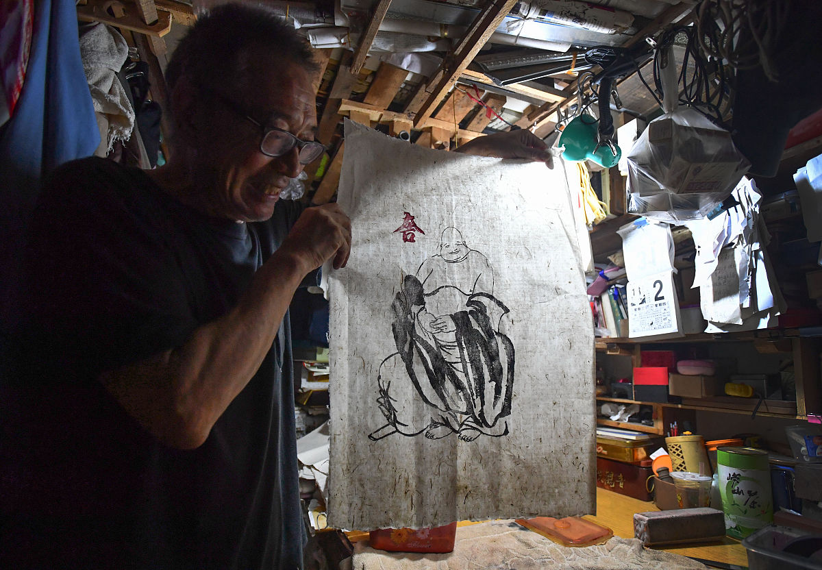 2018年8月18日,山东青岛,复刻拓印好的版画拎印.高文举老人年过古稀,