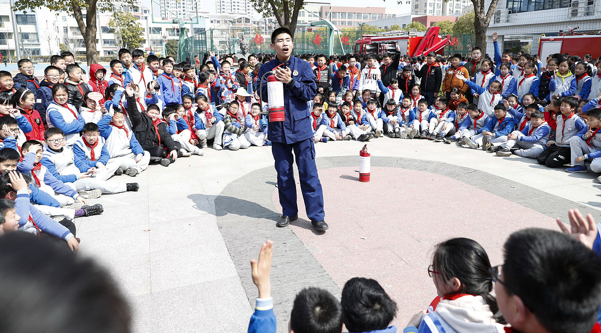 2019年3月25日,江苏淮安,天津路小学生听消防员讲解灭火器的使用方法.