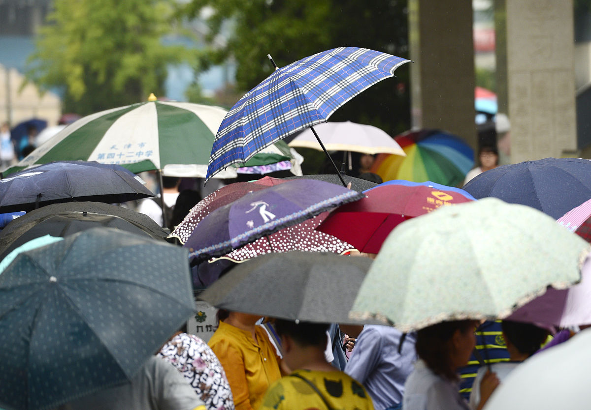 2018年6月7日,全国高考第一天,天津下起阵雨,考生的父母和同伴在雨中