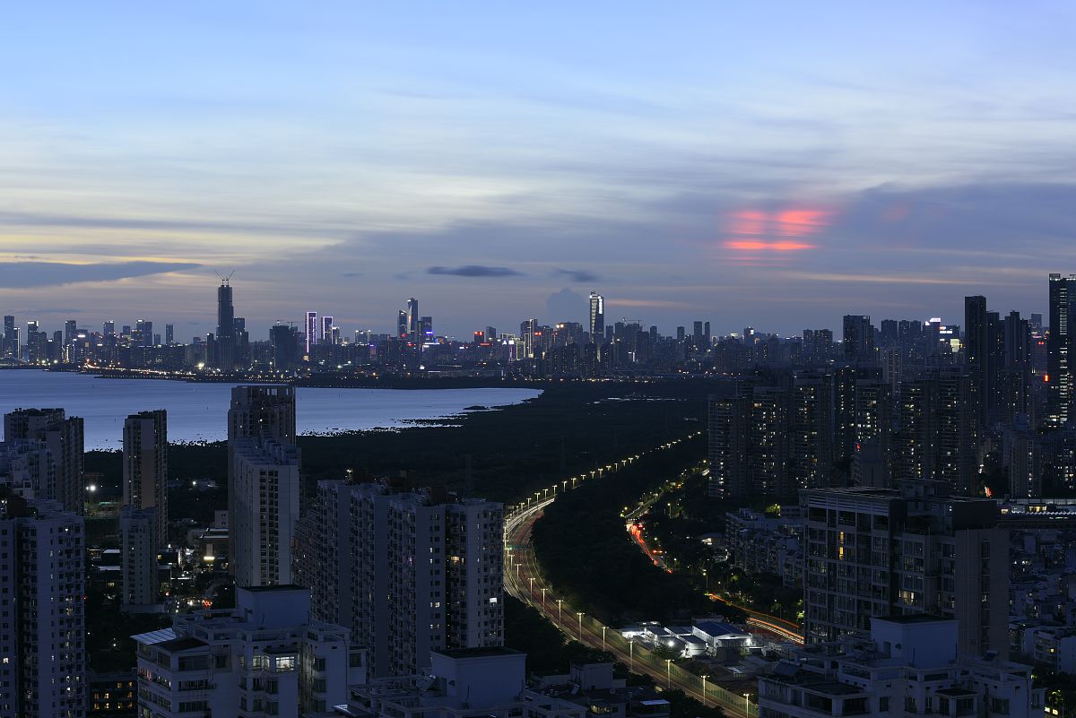 2021年5月23日,深圳湾日落时天空出现了绯红色彩霞.