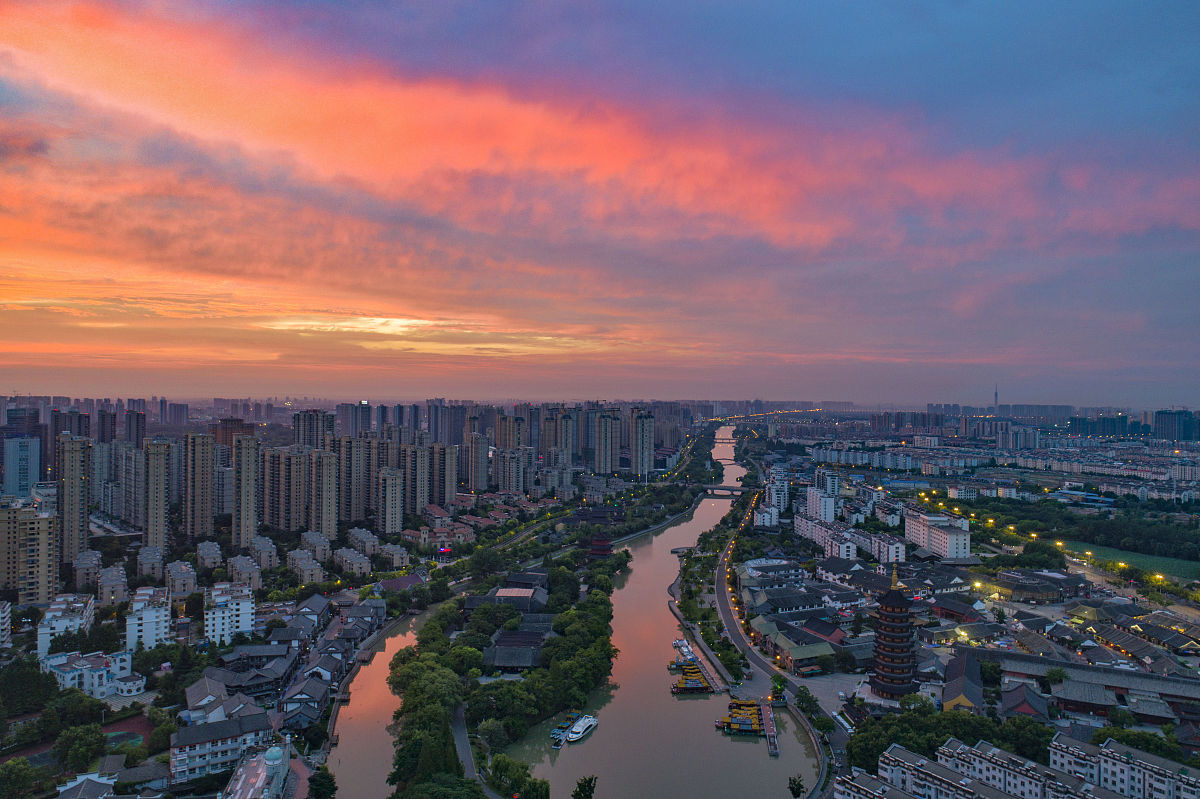 2020年7月26日,江苏淮安,里运河上空朝霞似火,将河畔的城市装扮得十分