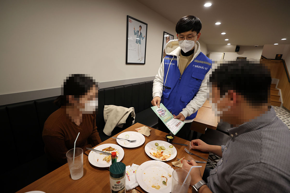 当地时间2020年11月13日,韩国首尔,首尔官员在当地餐厅检查口罩佩戴情