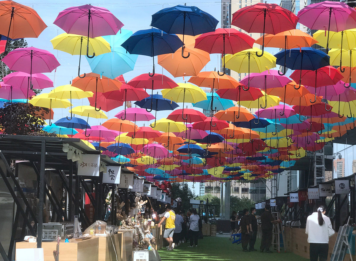 2020年7月24日,沈阳,百余把雨伞悬挂在街头,市民游走在伞棚中既能遮阳