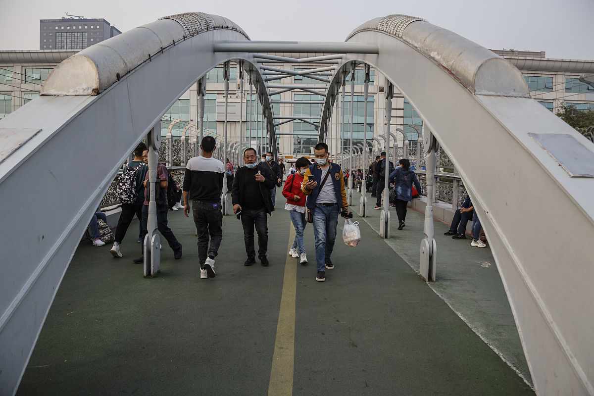 2020年10月9日,众多携带行李的游客在北京火车站站前广场进行候车.
