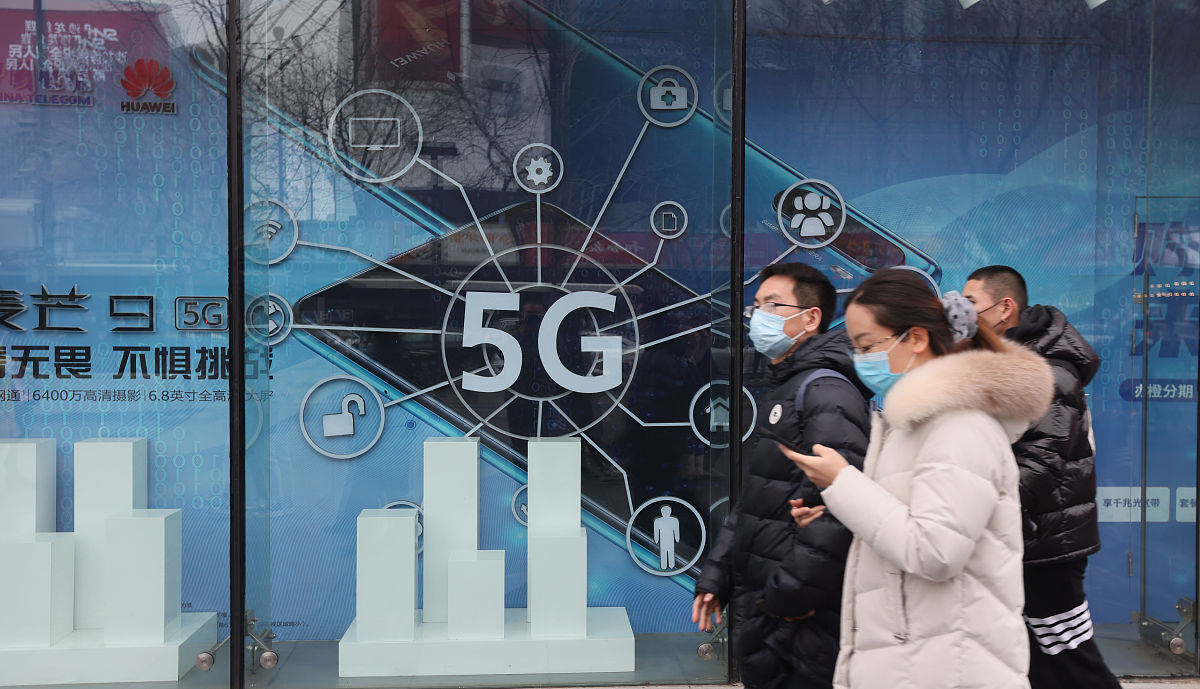 2021年2月14日,北京,行人从中国电信5g通信广告前经过.