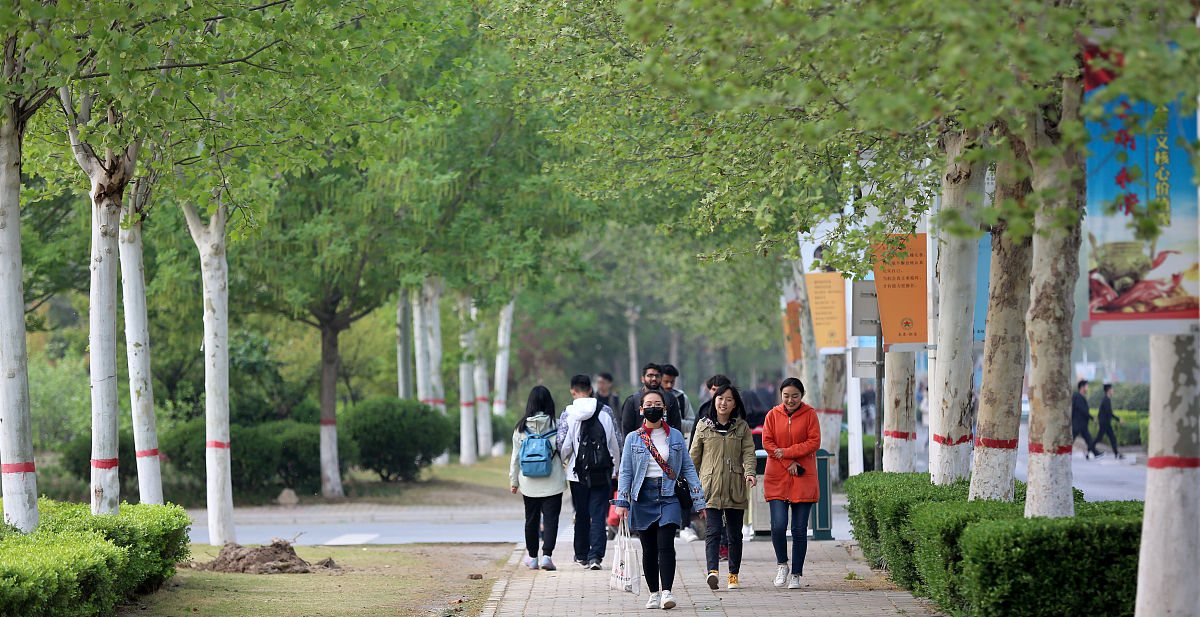 2019年4月8日,河南省郑州市,气温下降,行走在郑州大学校园内的学生们