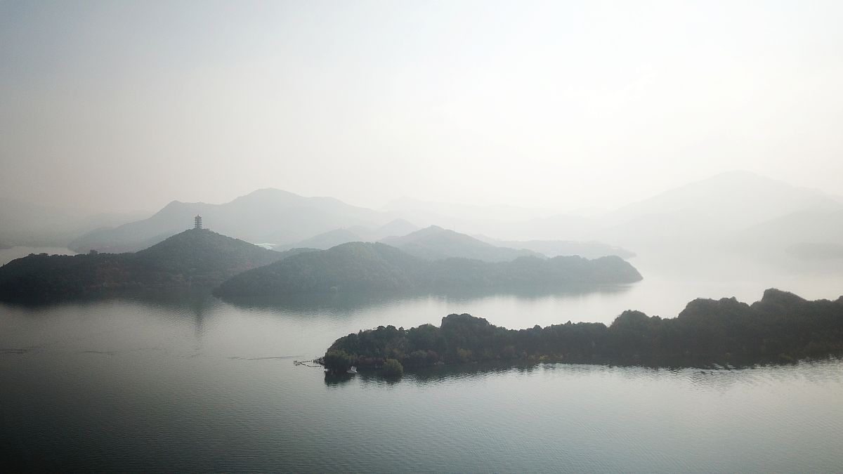 2018年10月17日,北京平谷金海湖被一片薄雾笼罩,宛如一副山水画卷,甚