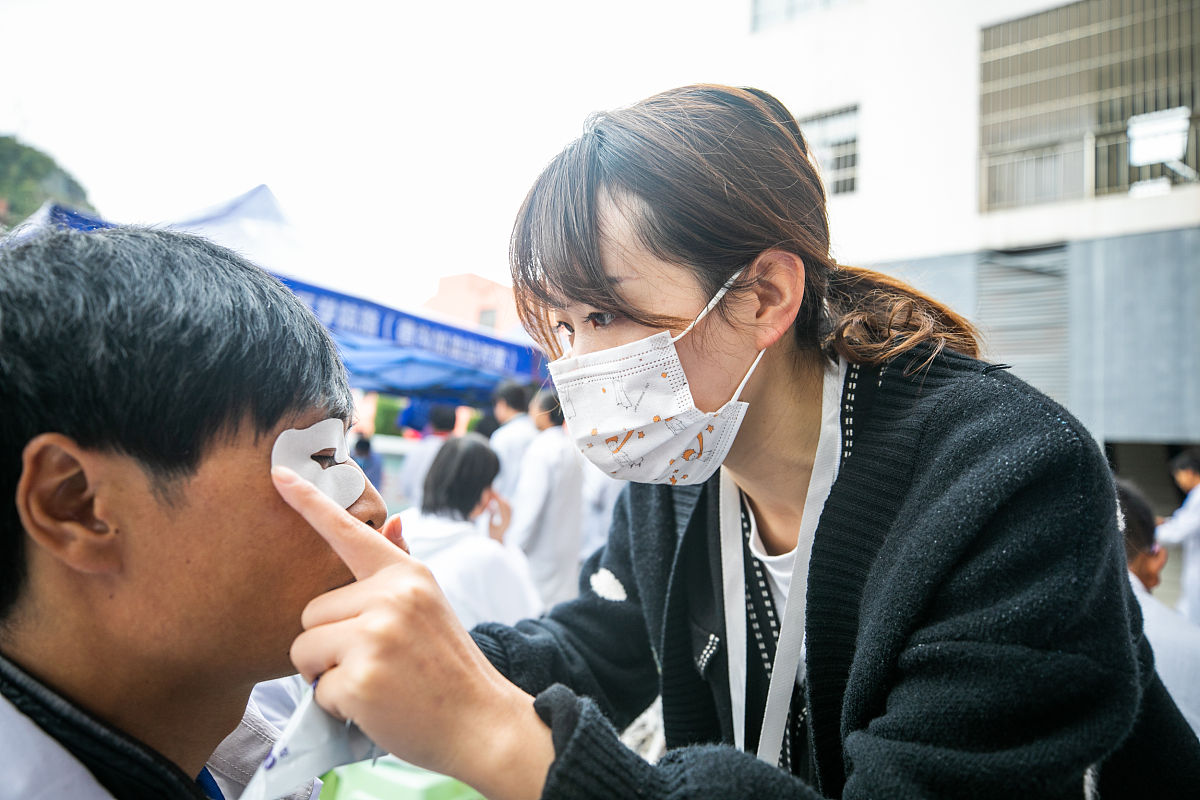 2021年10月15日,工作人员正在贵州省毕节市盲人技能培训学校为学员进