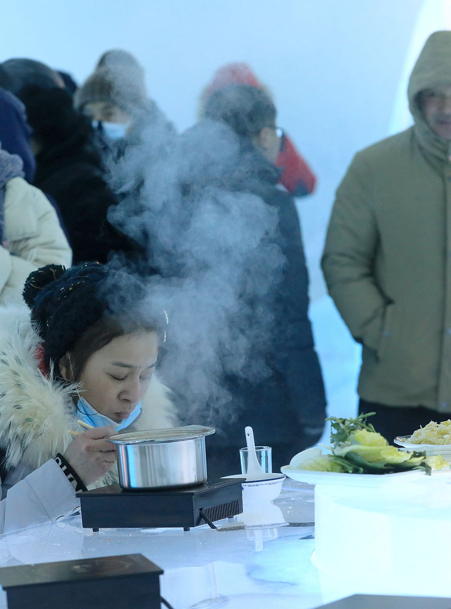 在冰雪大<strong>世界</strong>,冰屋子火锅开业,不少游客坐在冰凳子上,围着冰桌子吃