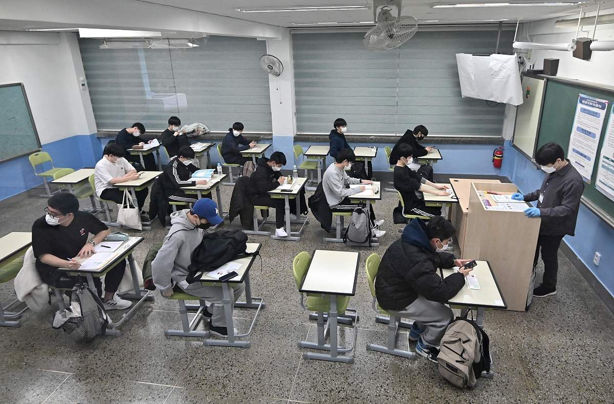 当地时间2021年11月18日,韩国首尔,考生们相继进入考场.韩国2022学年