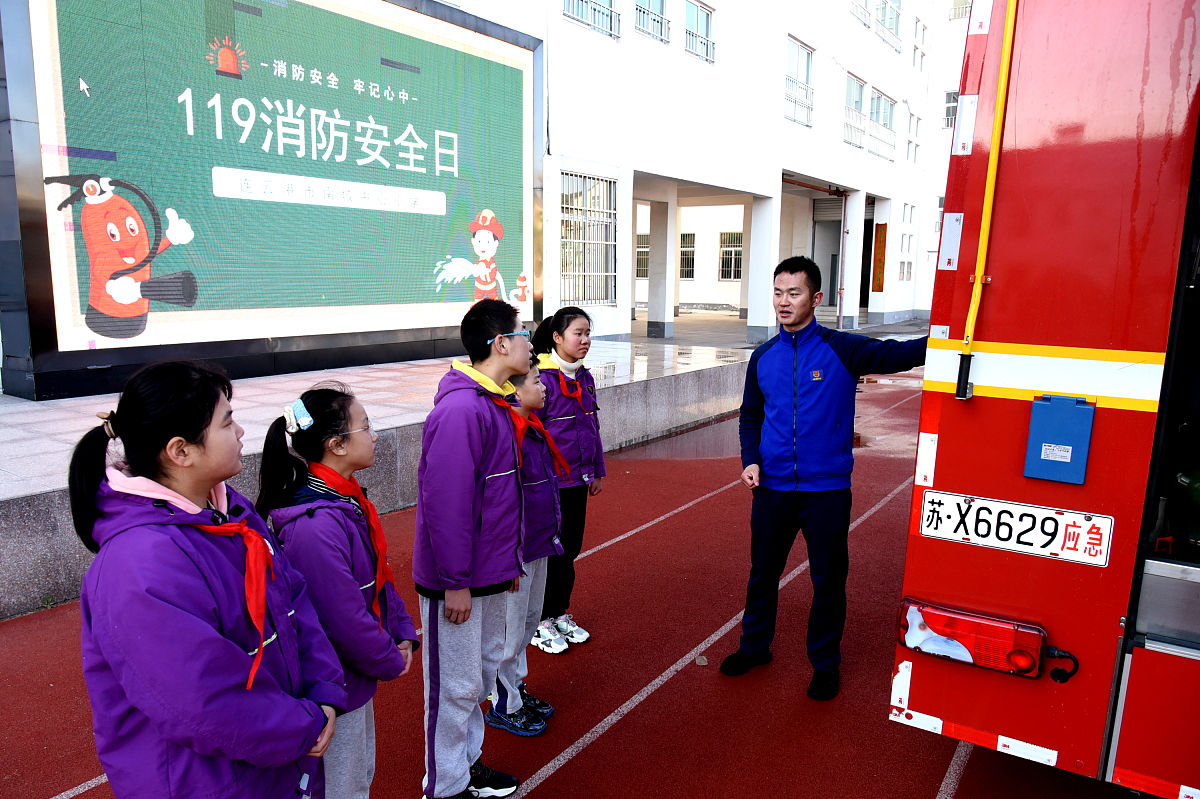 2021年11月8日,江苏连云港,海州区南城中心小学,消防员给小学生讲解消
