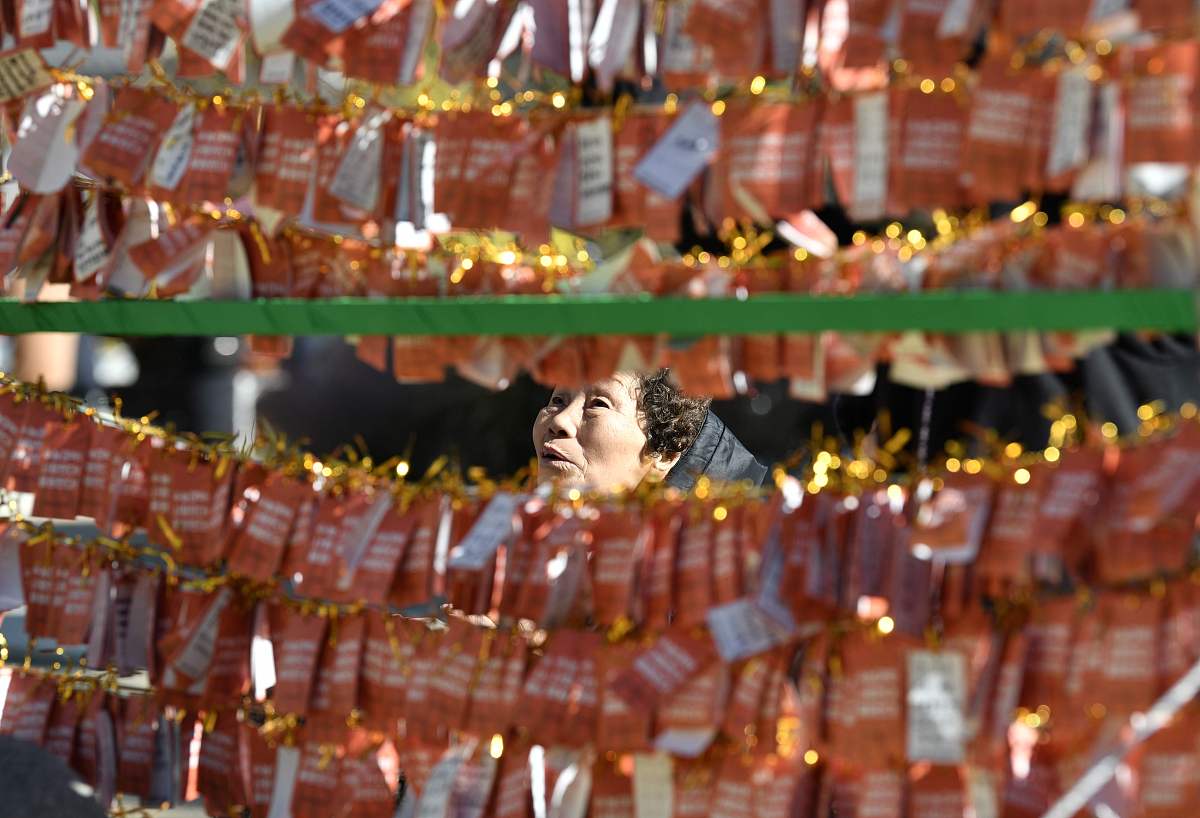 当地时间2019年11月14日,韩国首尔,女子在曹溪寺一排排的卡片前祈祷,