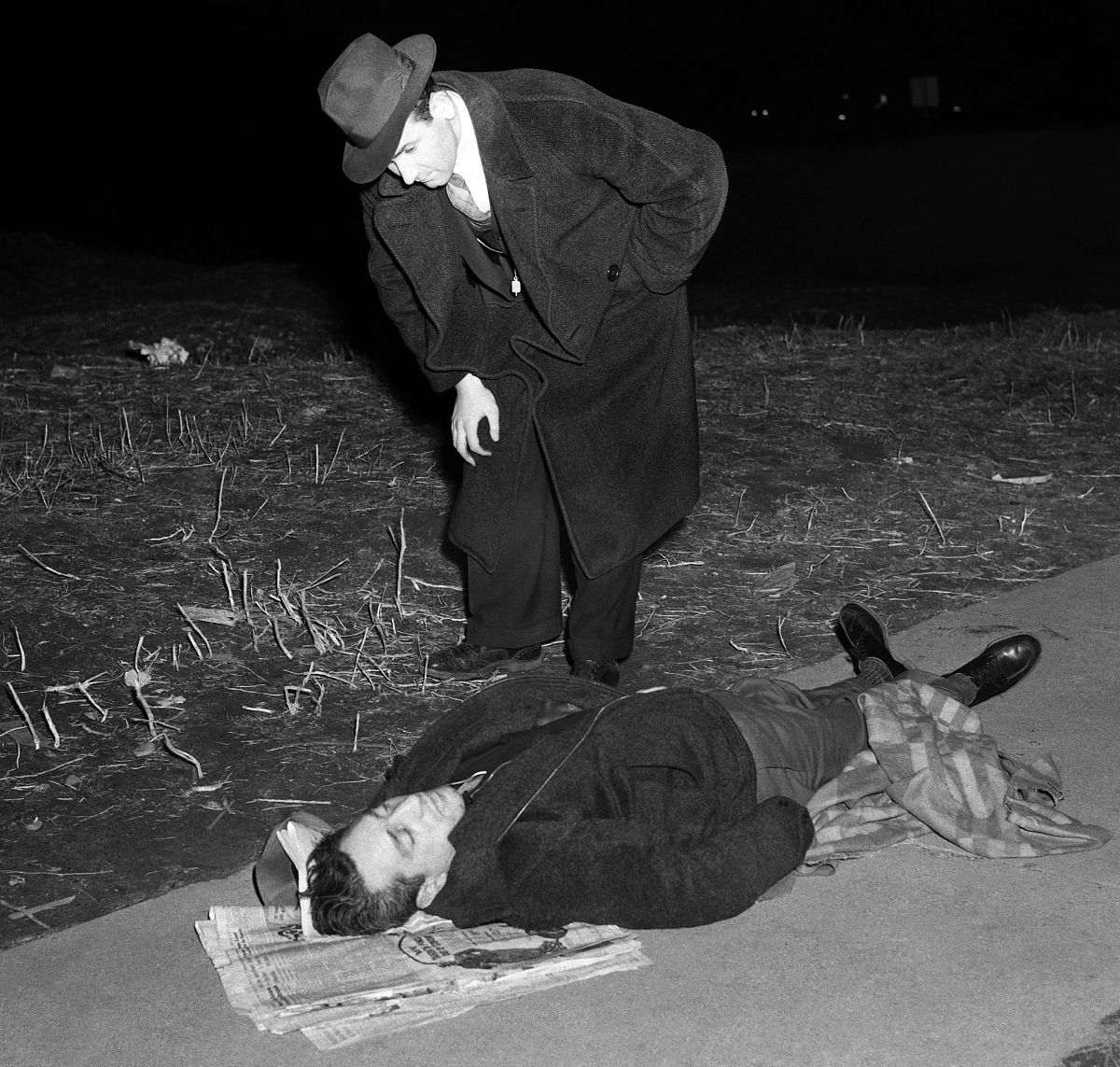 brooklyn, ny - 1940's: a detective examines the murder scene as 